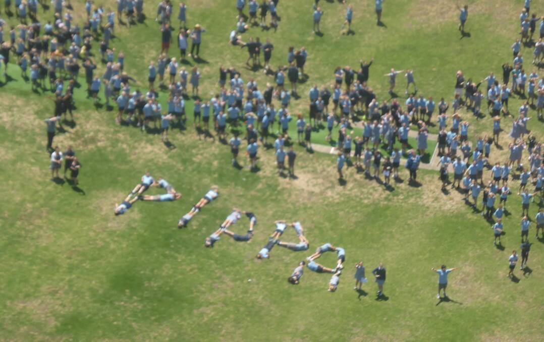 Pippa's St Joseph's Primary School friends spell out their surprise greeting on the school grounds.