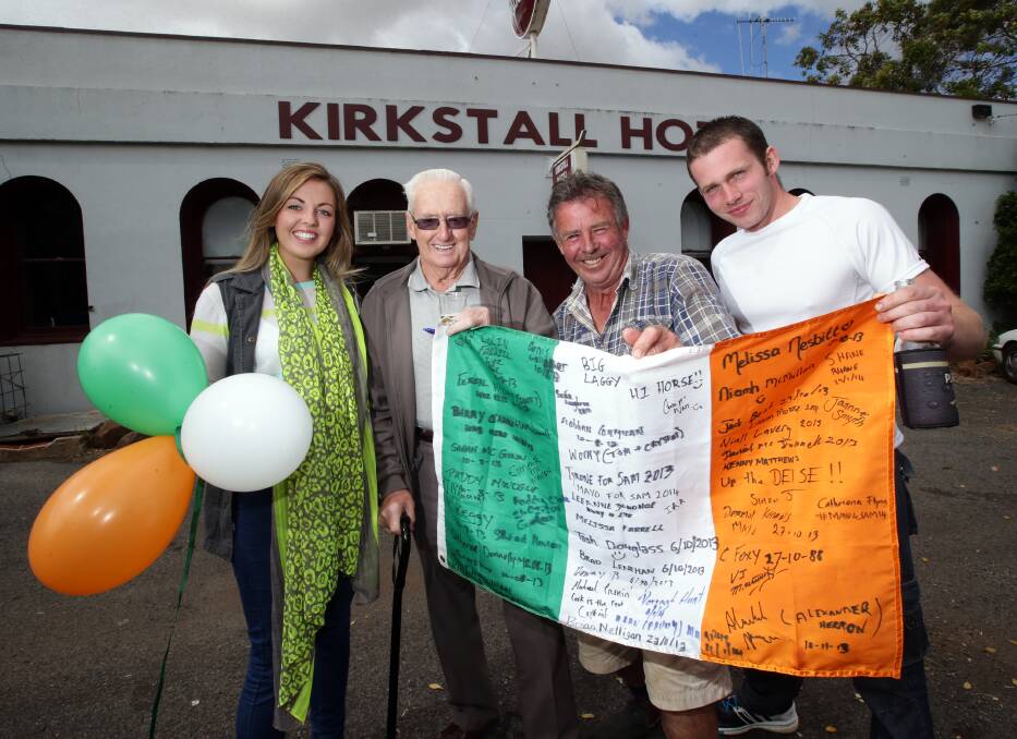 Melissa Nesbitt (left) and Paddy Clarke (right), both from Ireland, join Kirkstall locals Brian Lenehan and Mick Finnigan in preparing for today’s St Patrick’s Day celebration. The flag bears the signatures of the many Irish visitors and expats who have visited the town’s pub.