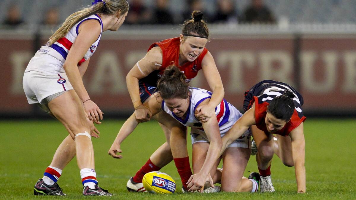 Emma Kearney (on ground), playing for the Western Bulldogs, competes for the ball against Melbourne in the inaugural AFL women’s exhibition match at the MCG last year.