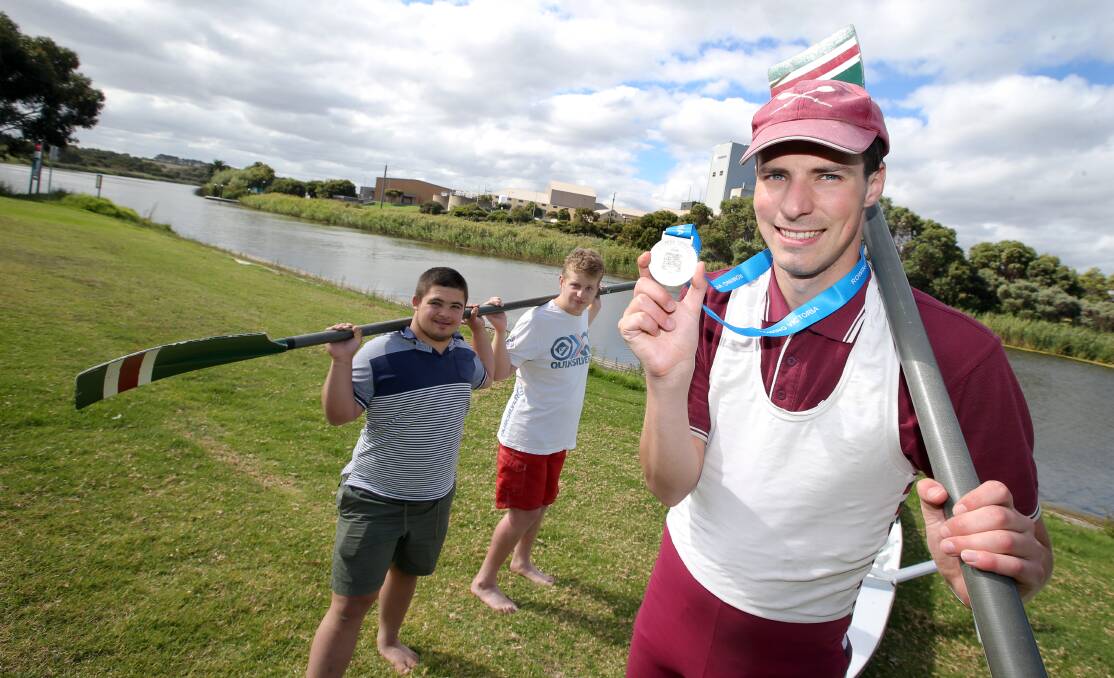 Nestles Rowing Club member Aaron Skinner displays the medal he won for the 1000-metre adaptive single scull at the Victorian championships on the weekend, before a session on the Merri River yesterday with Mpower clients Sebastian Sarra and Phil Anderson. 150304DW18 Picture: DAMIAN WHITE