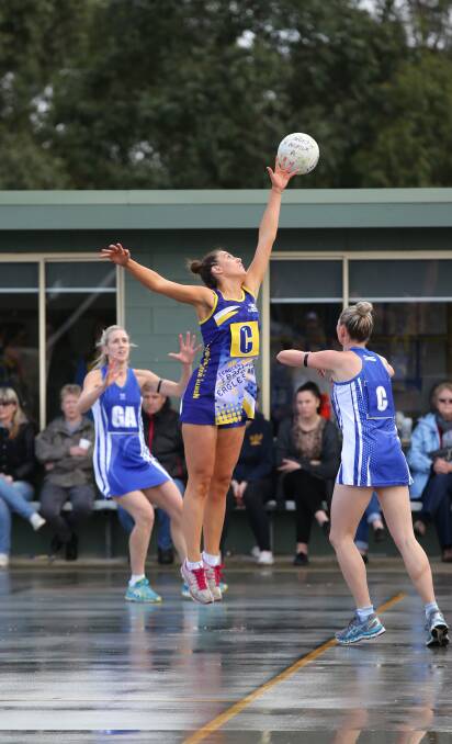 North Warrnambool Eagles’ Maddison Smedts (centre) stretches high in a bid to intercept a pass from Hamilton Kangaroos centre Alexandra Feely (right) to Clare Crawford. 