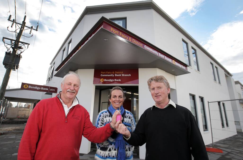 Port Fairy and District Community Bank chairman Peter Langley and director Nicole Dwyer receive the keys to the new Bendigo Bank branch from developer Mick Hearn. 