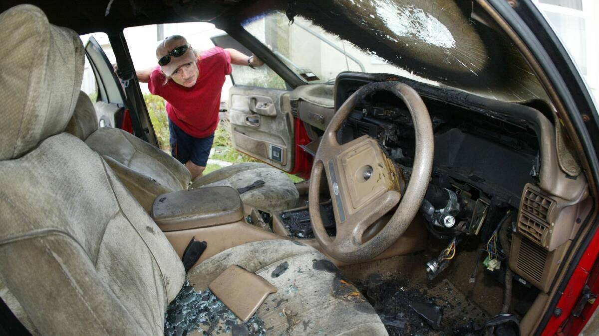 Warrnambool man Ian Anderton looks over his fire damaged 1985 XF Fairmont Ghia outside his home. 