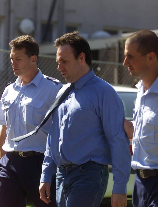 Graeme Slattery being led to a police divisional van outside the Warrnambool courthouse in 2004.