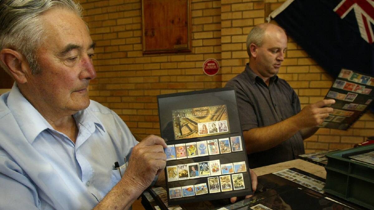 Stamp collectors Allan Strain and Darryl Smith sort through the collection of John Burn-Baley from Melbourne in the CWA hal.