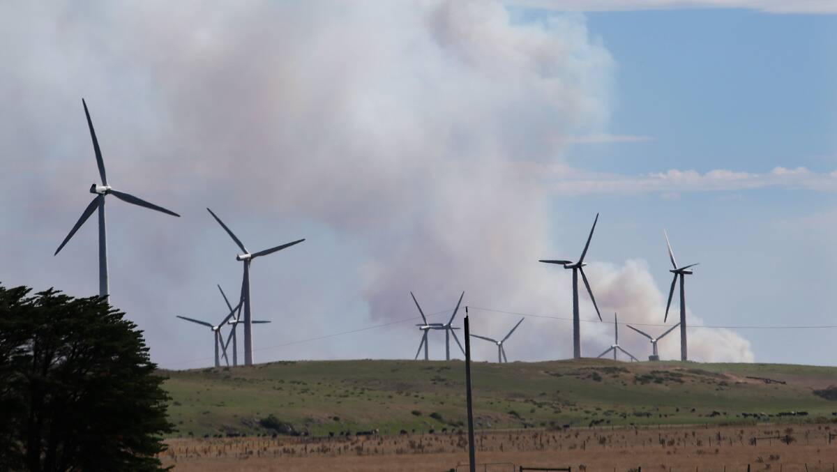 Country Fire Authority officials assured residents that the fire was contained to the southern foothills of Mount Clay. The Codrington wind farm is pictured with smoke from the fires yesterday afternoon.