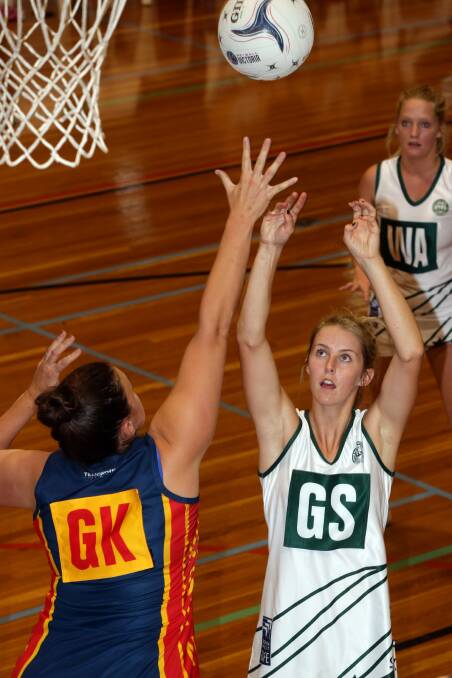 Hampden White's goal shooter Jaymie Finch shoots over Warrnambool and District goalkeeper Lisa Anders in State League netball round three at the Warrnambool Stadium. 