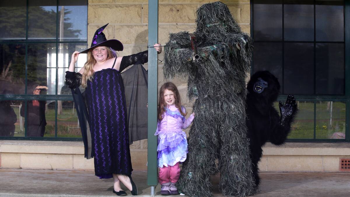 Charlotte Watts, 9, with Emily Leddin, 5, and Anthony Leddin dressed as a Yowie. 