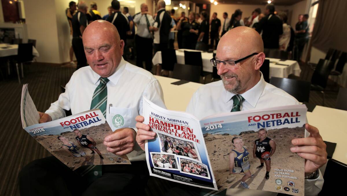 HFNL president Hugh Worrall and CEO Mike Farrow get a sneak preview of The Standard's footy and netball guide, published Friday, during the HFNL season launch.