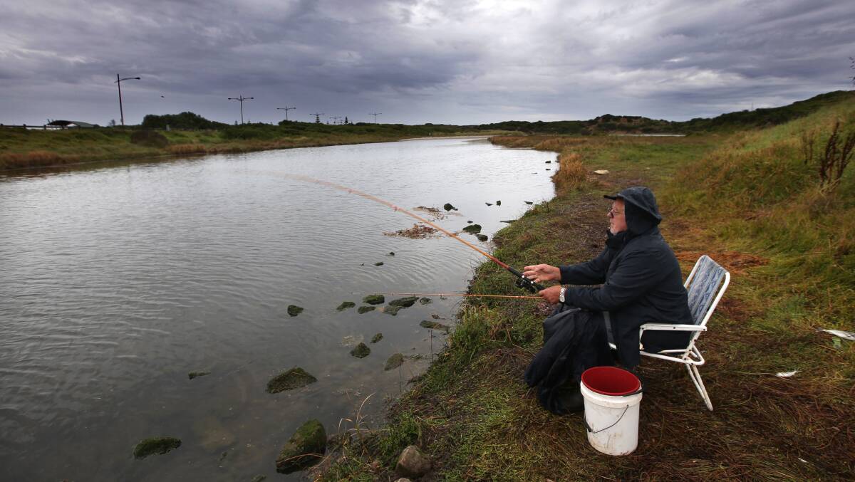 Warrnambool man Terry Morrissey fishing at Merri river in the rain. Picture: DAMIAN WHITE