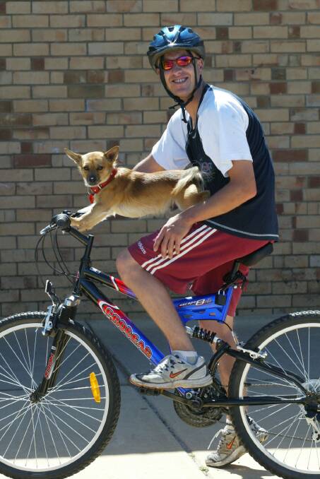 Troy McGlynn with his dog Rocket who helps steer the bike while riding around town.