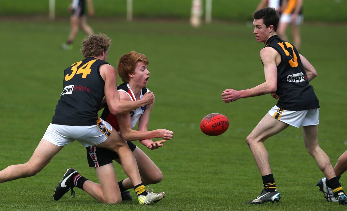 Koroit player Willem Drew tries to get the ball past Portland's Charlie Woodford and Matt Kelly on Saturday. Picture: DAMIAN WHITE