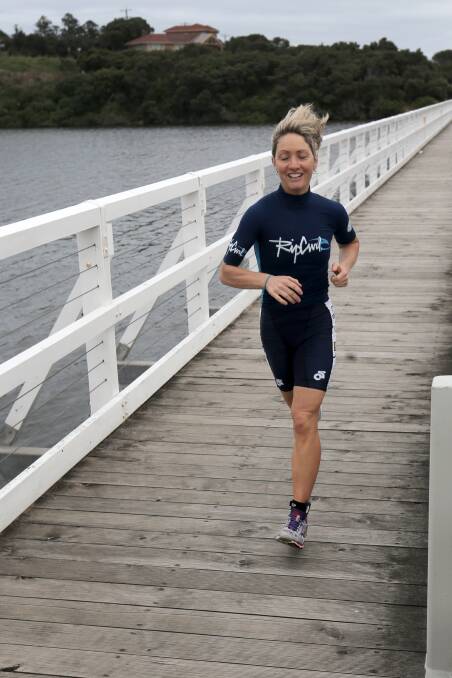 Women's event winner Lisa Worrall runs across the Hopkins River, at the end of the first of three run legs in the Enduro Triathlon. 