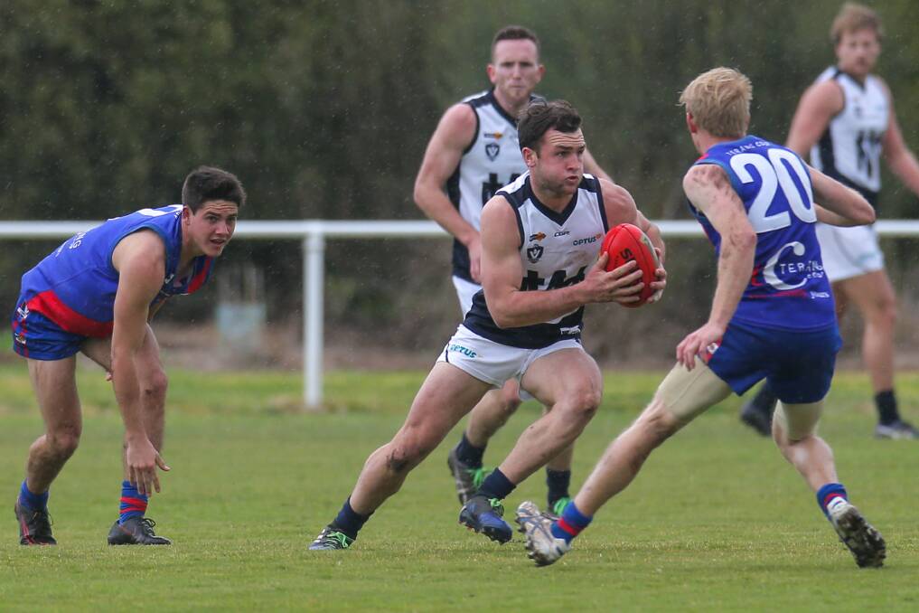 BREAKING THROUGH: Warrnambool's Tom Ludeman forges a path through traffic against Terang Mortlake at D.C. Farran Oval on Saturday. Picture: Rob Gunstone