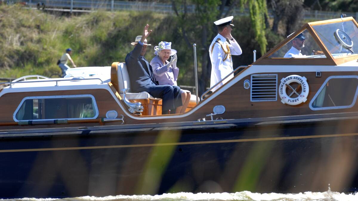 The Queen and the Duke of Edinburgh wave from the Admiral's Barge on Canberra's Lake Burley Griffin in October 2011. Picture by Graham Tidy