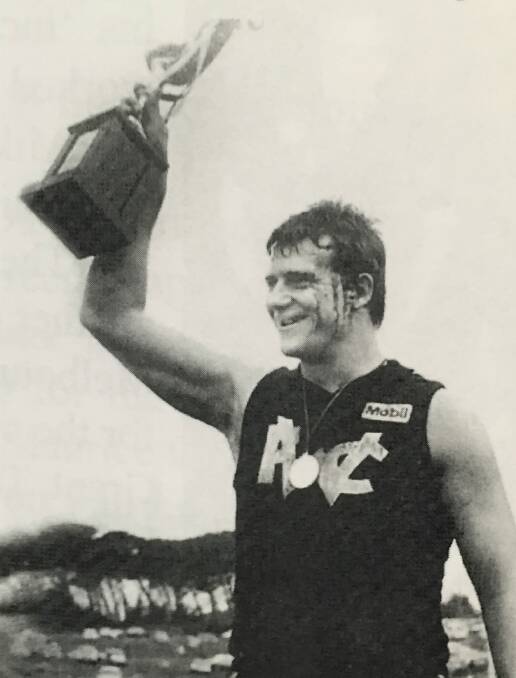 LEADER: A bloodied Warrnambool coach Grant Thomas holding up the 1986 Hampden league premiership cup. Thomas led the Blues to four grand final wins in a row.