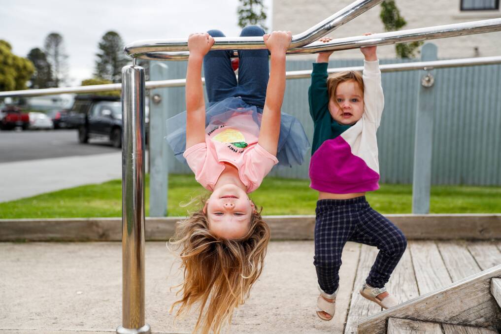 AT PLAY: Piper and Ruby Church from Port Fairy hang from the rails at the Fiddlers Green