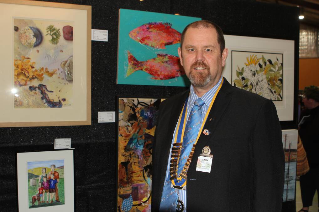 SUCCESS: Rotary Club of Warrnambool East president Mark Taylor with some of the many paintings on display. Picture: Anthony Brady