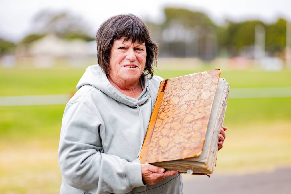 Warrnambool and District Cricket Association committee member Anne-Maree Huglin with a scrapbook from the late Cyril De Grandi. Picture by Anthony Brady