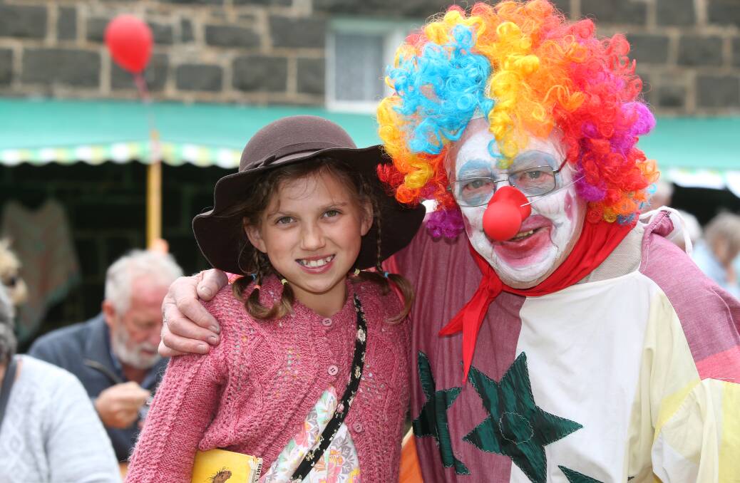 Ruby Conlan, 12, of Port Fairy, makes friends with Len the Clown on Sunday at the Strawberry Fete. 