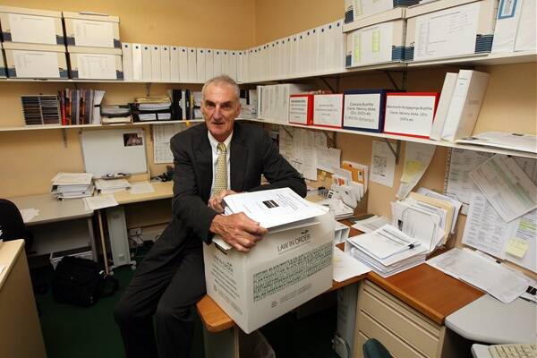 Brendan Pendergast from Maddens Law firm with folders and documents for Black Saturday Fires cases.