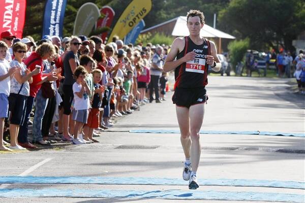 Men’s 10km race winner Shane Nankervis crosses the finish line to claim his second victory in the event.