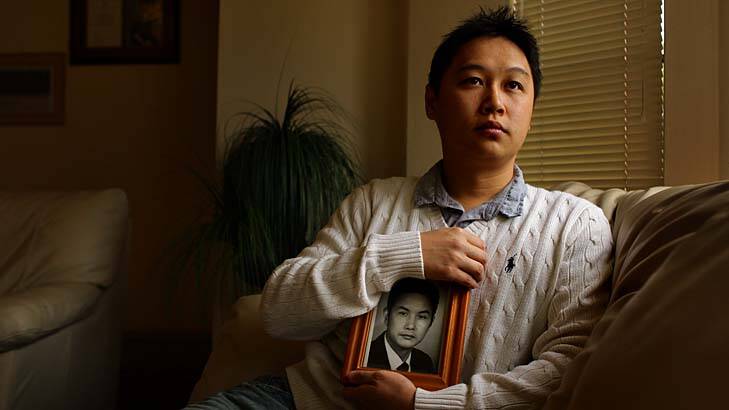 Tommy Du, at his home in Sydney, holds a photograph of his father Zu Yingdu.