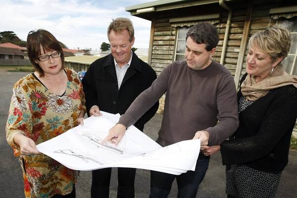 Brophy client services manager Ruth Isbel, Brophy CEO Francis Broekman, architect Tim McLeod, and SW TAFE's centre for education and early childhood development manager Jenny Madden examine the plans for the redevelopment of the Log Cabin Motel site on Raglan Parade.