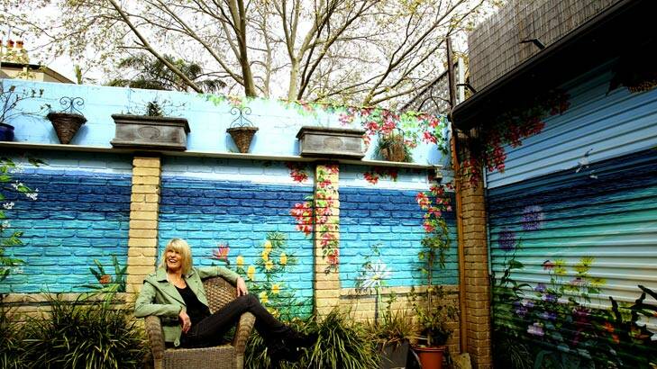 Another world … Annette Barlow with her work in the backyard of a home in Glebe.