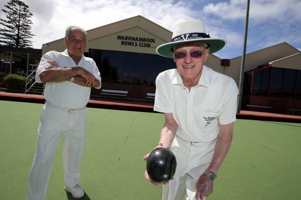 Warrnambool Bowls Club veteran Max Hammond (right) celebrates his Victorian past presidents’ association life membership with a game of bowls, watched by Western District Group president Lyall Gill.