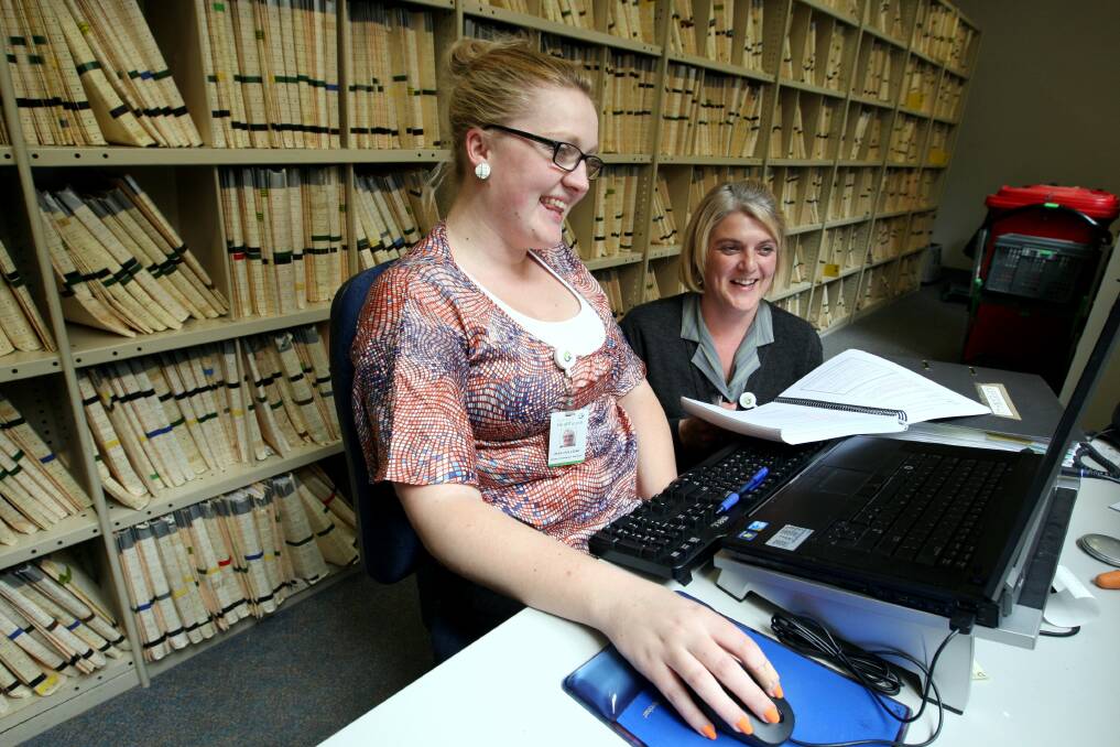 South West Healthcare health information manager Jess Holliday (left) and health information services clerk Janelle Gladman test the new electronic administration system for recording patient information, flanked by existing paper files. 