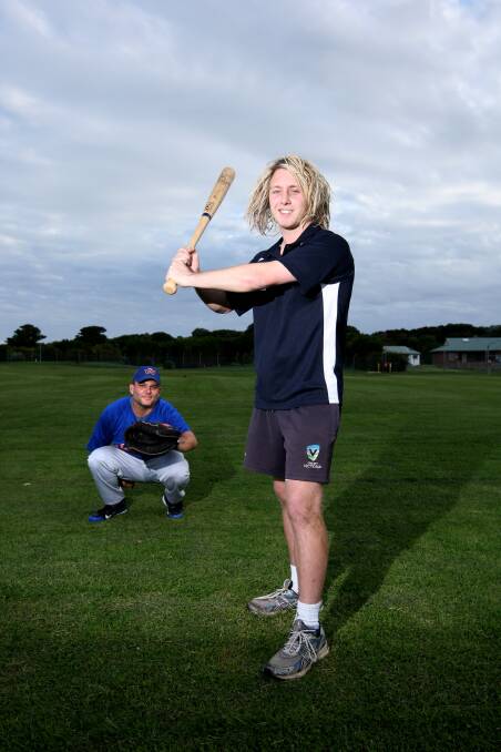 Warrnambool Angels’ keeper John McLam waits for cricketer, and Pirates coach Steve Mirtschin, to swing his baseball bat. 