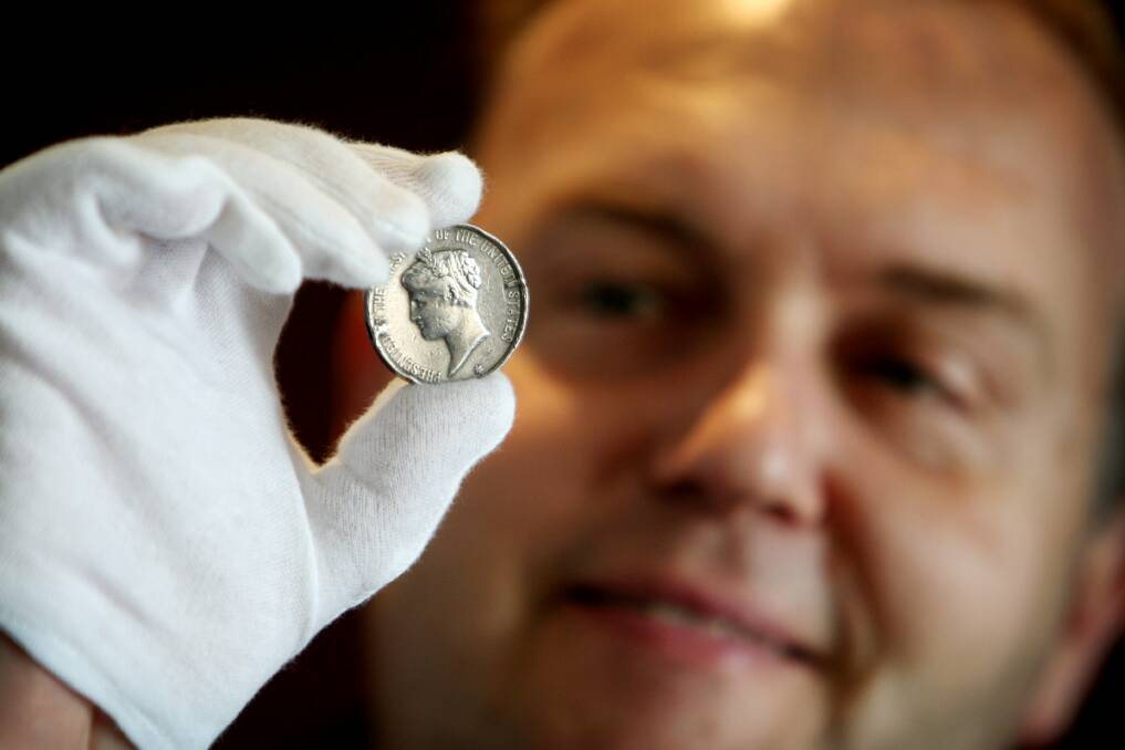 Flagstaff Hill director Peter Abbott eyes a medal awarded to rescuers of a shipwreck crew in 1880. 