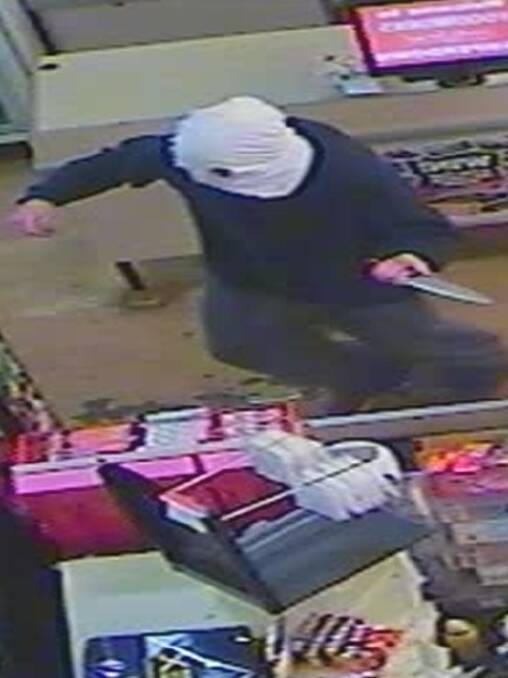 An armed bandit brandishes a knife during the June 1 robbery at the Camperdown Foodworks Supermarket last year.