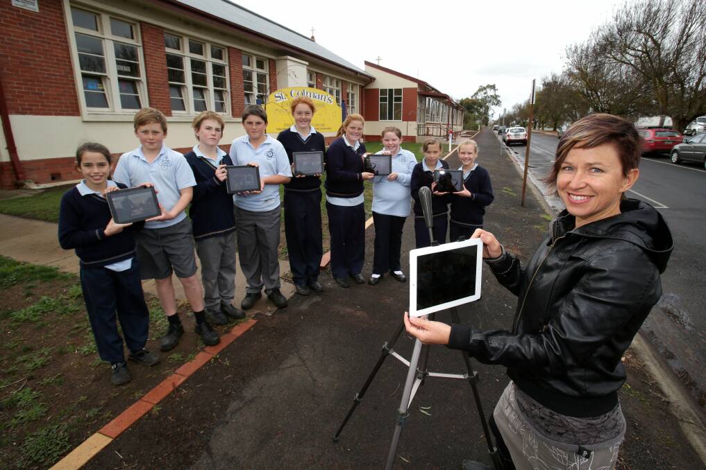 St Colman’s School pupils Keely Spoore, 10 (left), Lachlan Gedye, 11, Dustin Stapleton, 11, Lachlan Higginson, 11, Brodie Humphrey, 11, Taylah Casson, 11, Jordan Gray, 10, Imogen Faull, 11, and Isla Rous, 10, display some of their work on iPads for Colleen Hughson. 