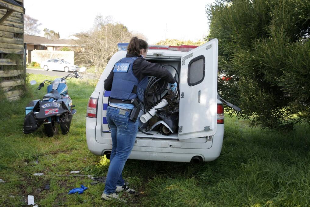 A police officer loads seized cannabis growing equipment into the back of a divisional van after raids yesterday on houses in Camperdown, Terang and Colac. 