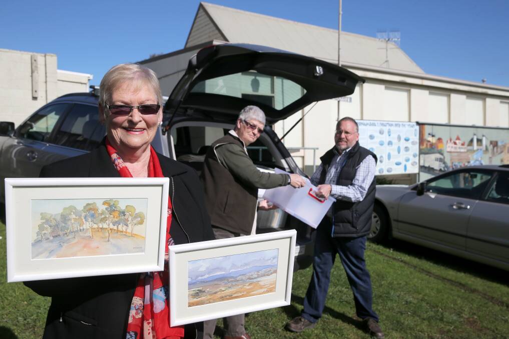 Warrnambool & District Artists’ Society president Maureen Healey, committee member Gwyn Taylor and vice-president Tim Walker with some of the 9x5 works.  Picture: ROB GUNSTONE