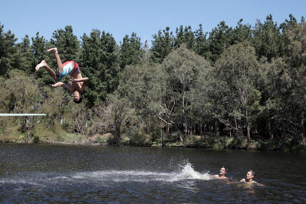 Jayden Square flips off the diving board at the Panmure swimming hole as his mates Paul Croft (left) and Allistar Bourke cool off in the water. 