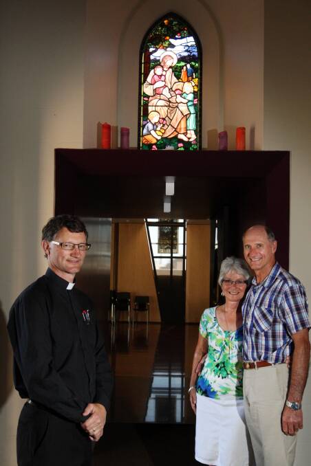 Father Scott Lowrey and Elizabeth and Michael Halls admire the stained-glass window installed at Christ Church in memory of the Halls’ daughter Natasha and her family.