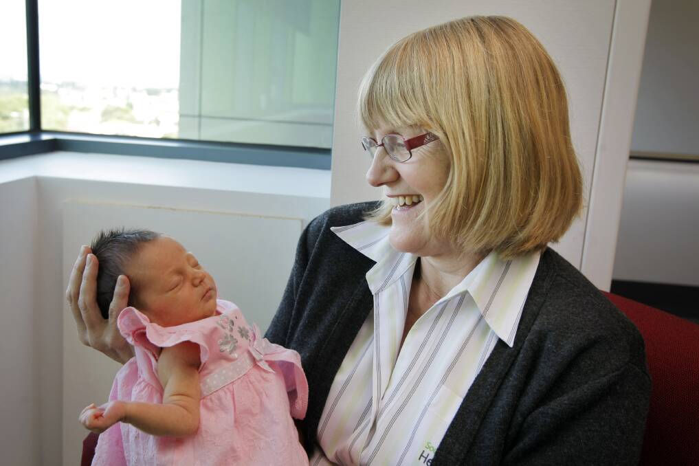 Retiring midwife Dianne Lyon cuddles newborn Indi Neale — one of hundreds of babies she has helped bring into the world over the past 40 years.