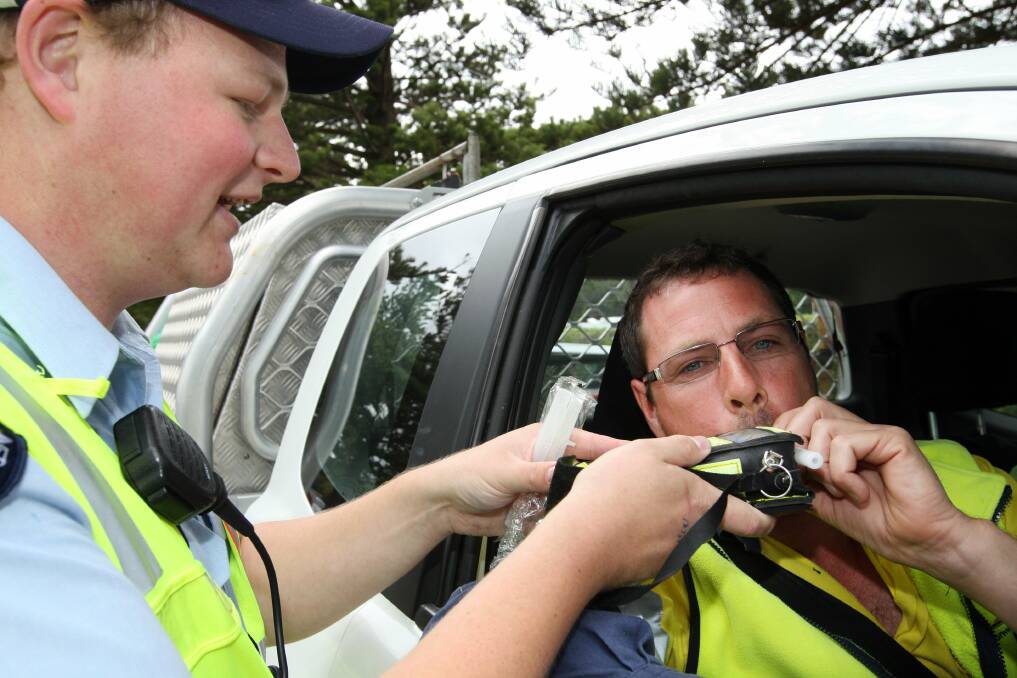Constable Ross Paton breath-tests driver Andrew Gustus on Pertobe Road yesterday.