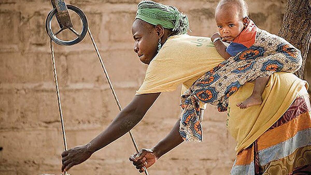 Baby Nariawa is taken along for the ride, as her grandmother Sabio collects water from the village well in Senegal. Photo: Meg Hansen