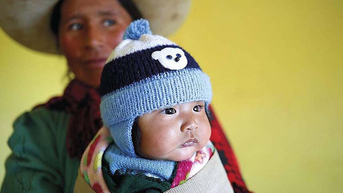 Virgilia swaddles baby Edwin in North Potosi, Bolivia. The local custom is thought to help keep the baby’s back strong. Bolivia. Photo: Steve Fraser