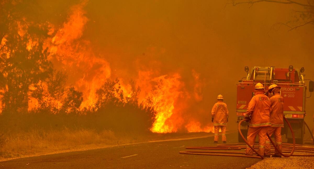Firefighters prepare to defend the Glenmaggie Caravan Park under the threat of flame in eastern Victoria.