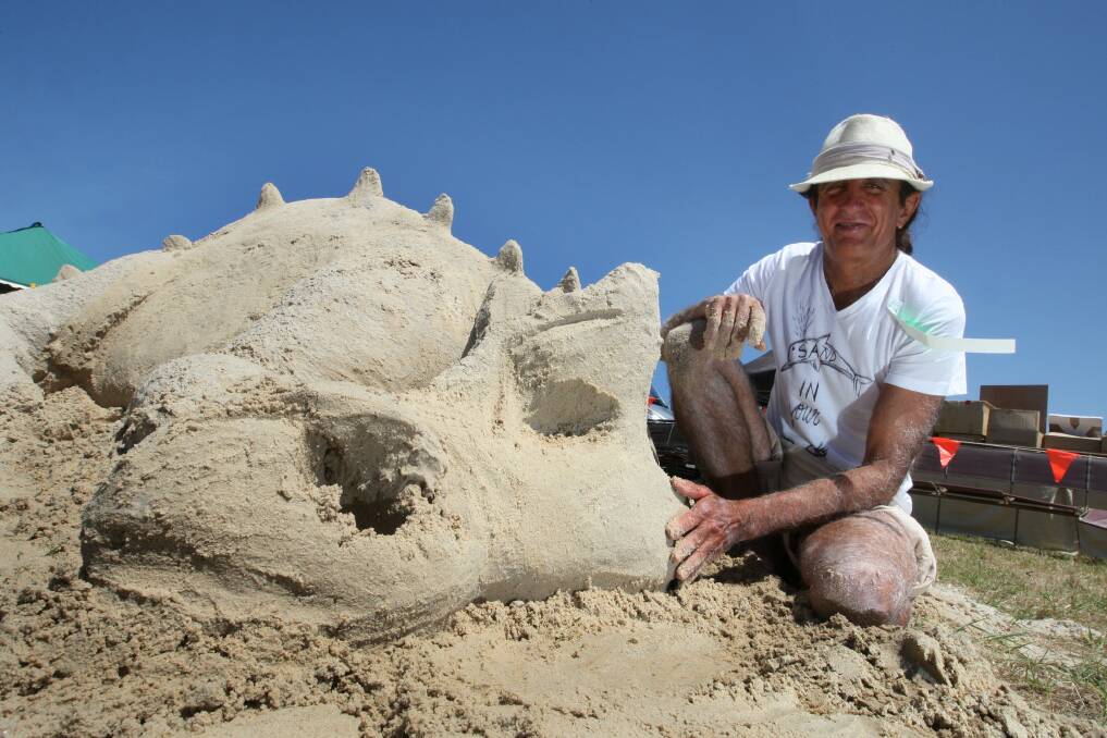 Dennis Massoud "The Sandman" from Noosa Heads builds a dragon sand sculpture. 