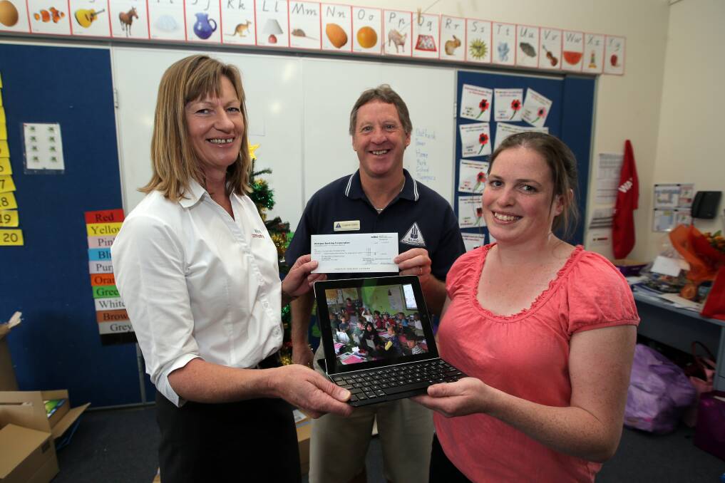 Director of WDEA Community Kim Williams (left) presents Our Lady Help of Christians principal Eugene Dalton and prep-grade 1 teacher Alison Quinn with a grant to provide specialist technology to help low-vision pupil Dan Duffy next year.