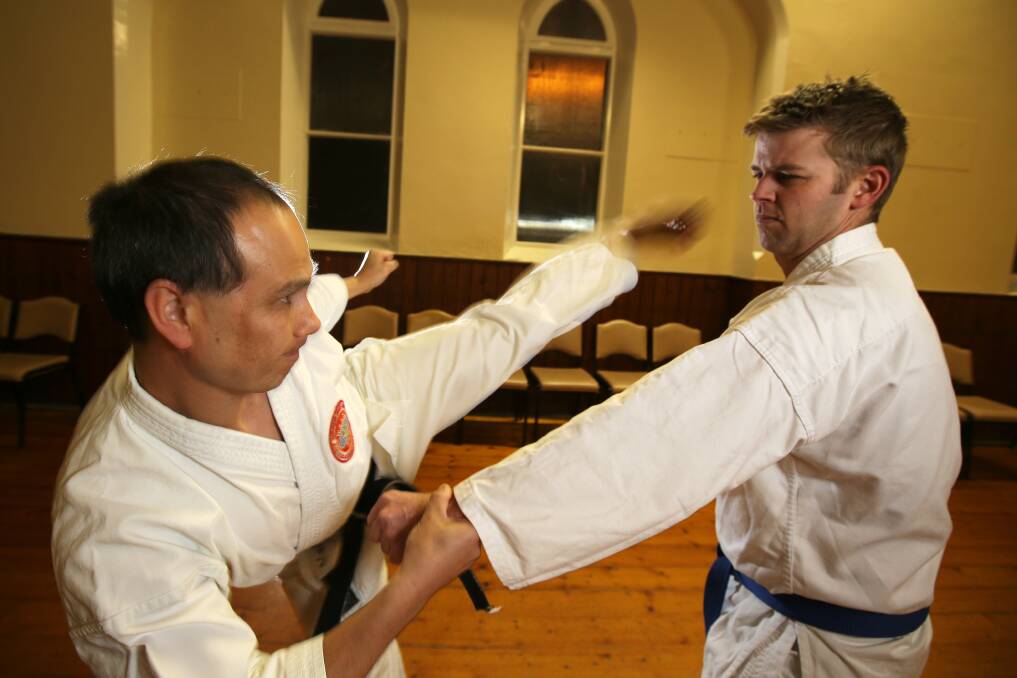 Sensei Stephen Hol practices his kicks against student Adam Lucas, as he trains for the World Shotokan Karate-Do Federation titles in Japan. Picture: ROB GUNSTONE