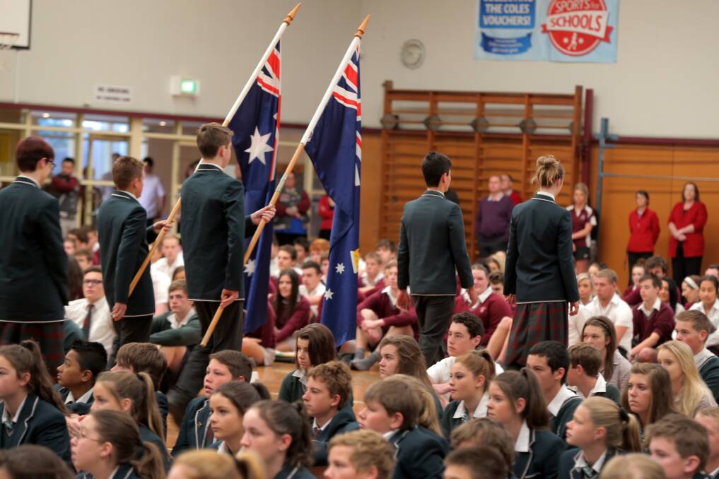 Students march out the flags at Brauer College's Remembrance Day ceremony. Picture: ROB GUNSTONE