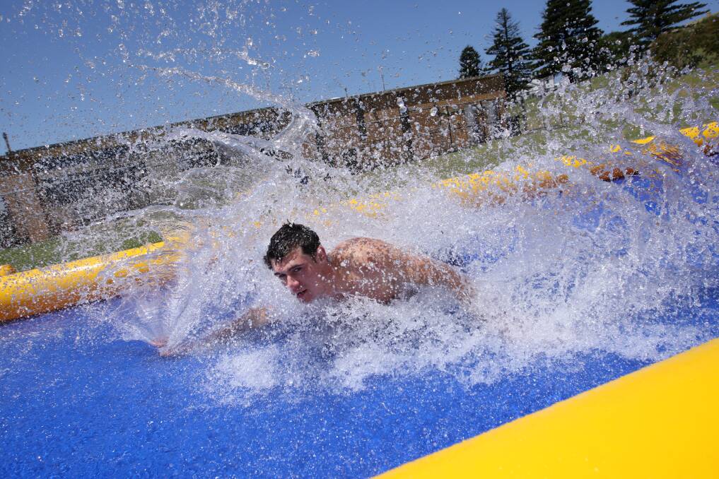 Lifeguard Adam Barnes tries out the new slippery slide.