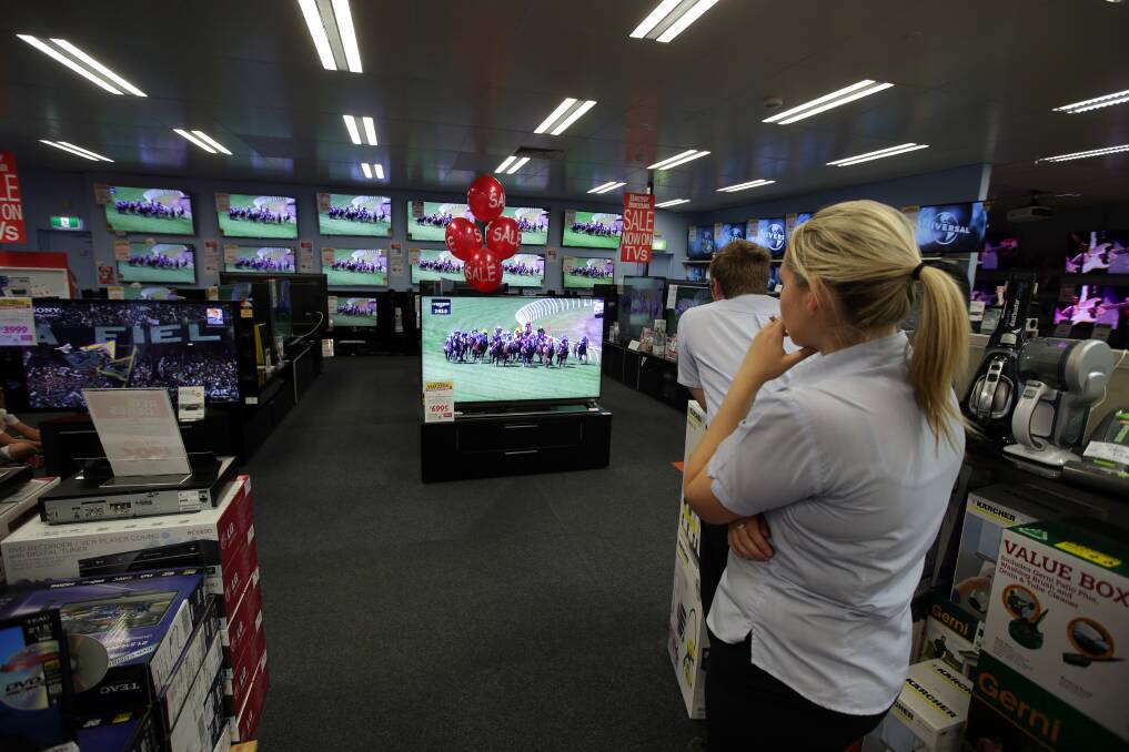 Harvey Norman customers and staff in Warrnambool pause to watch the Melbourne Cup. Picture: DAMIAN WHITE